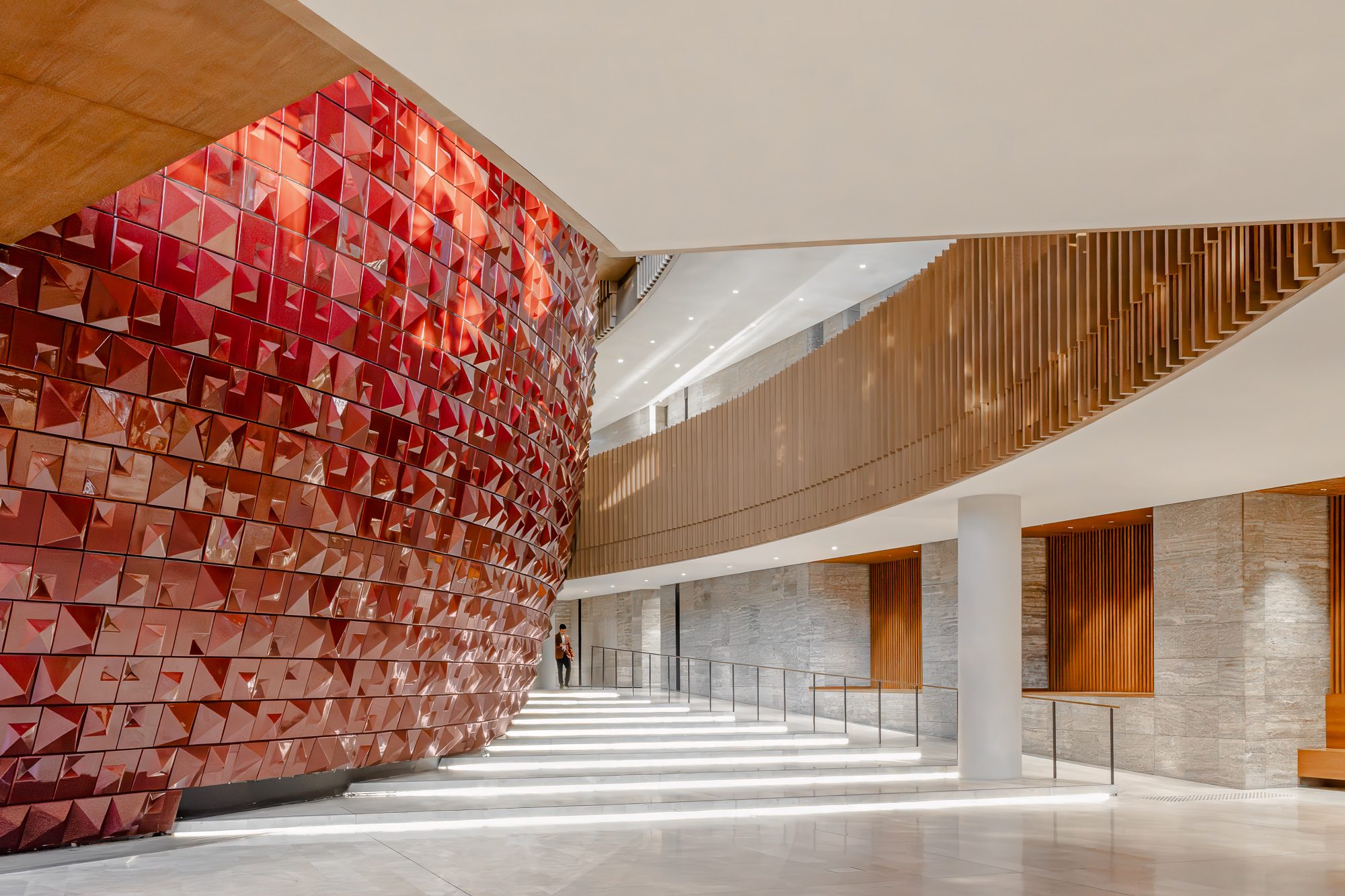 Red ceramic-tiled opera drum beside the illuminated grand stair, AKM