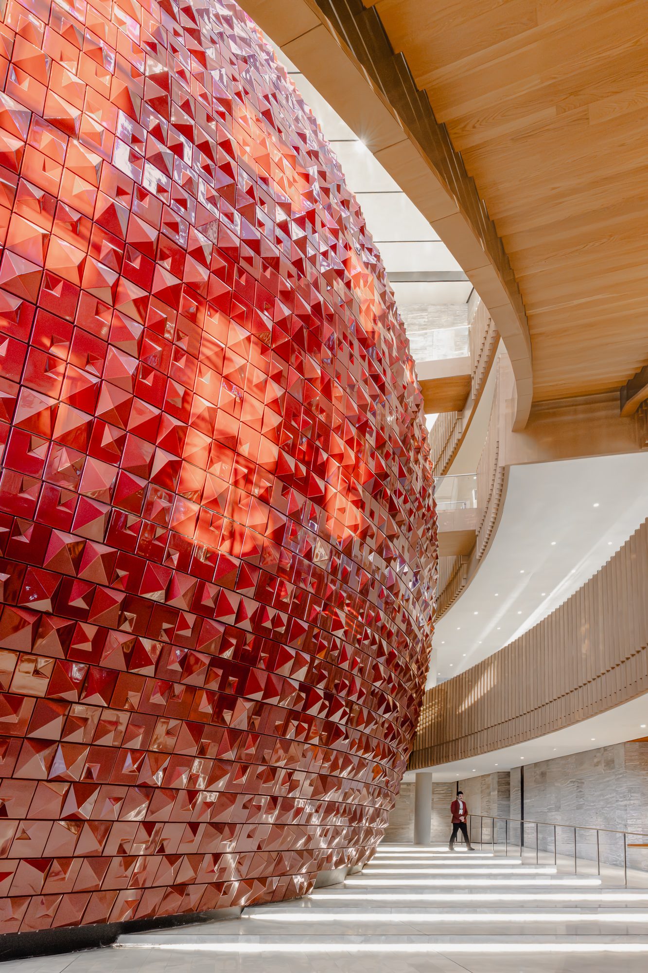 Red ceramic drum beneath the oak soffit above the foyer stair, AKM