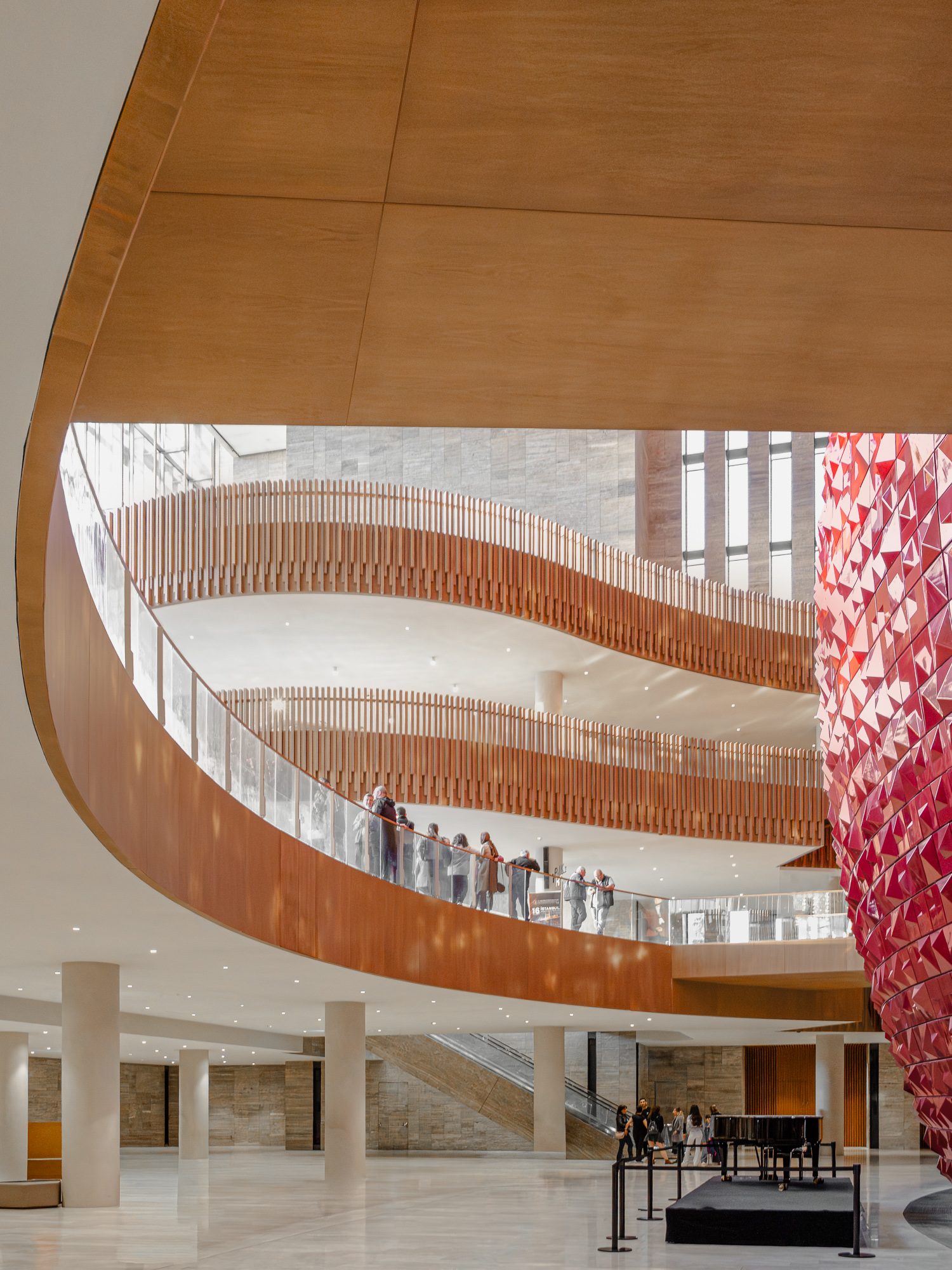 Curving oak balconies with visitors around the atrium, AKM