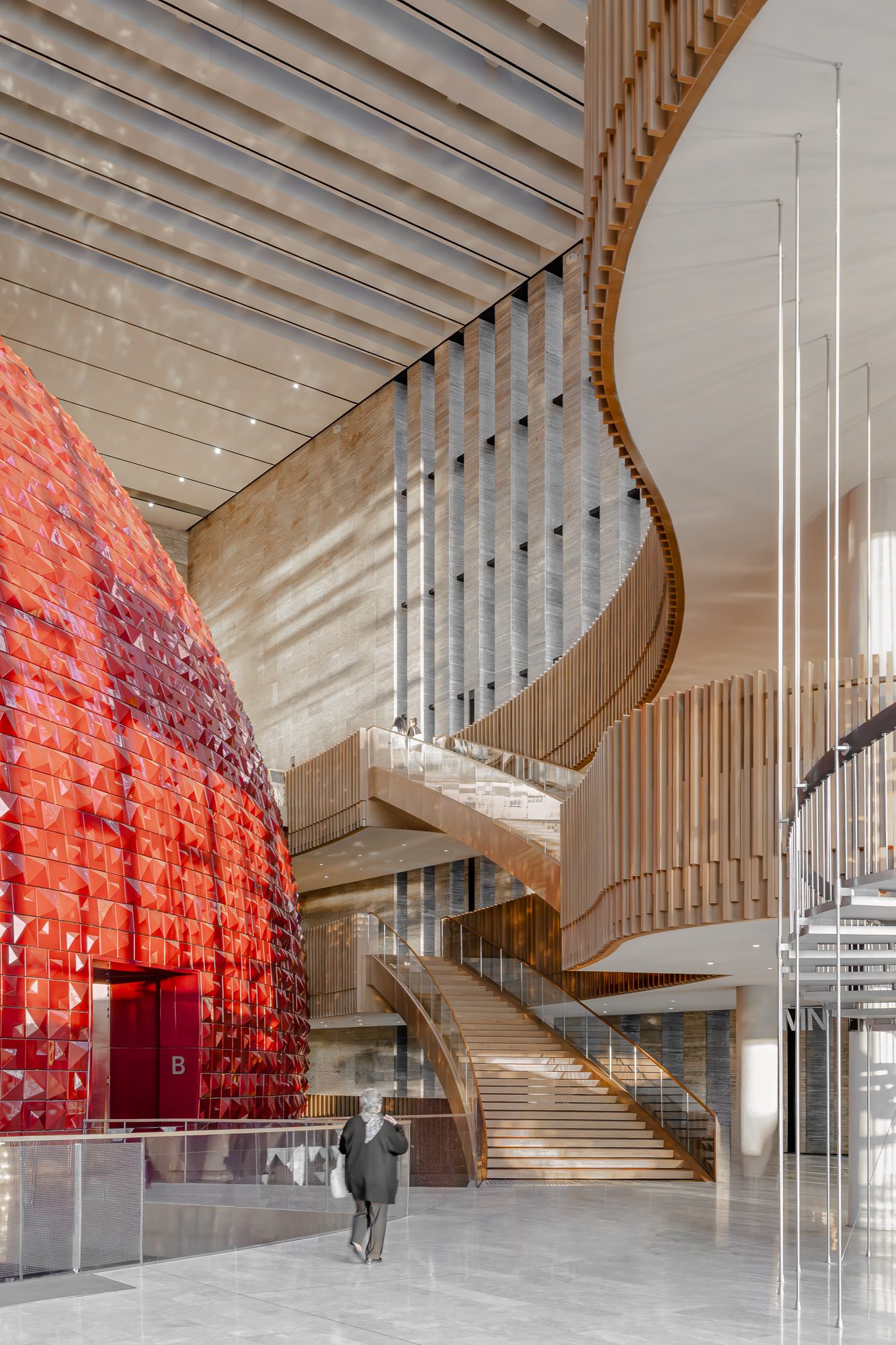 Visitors in the atrium beneath the red drum and spiral stair, AKM