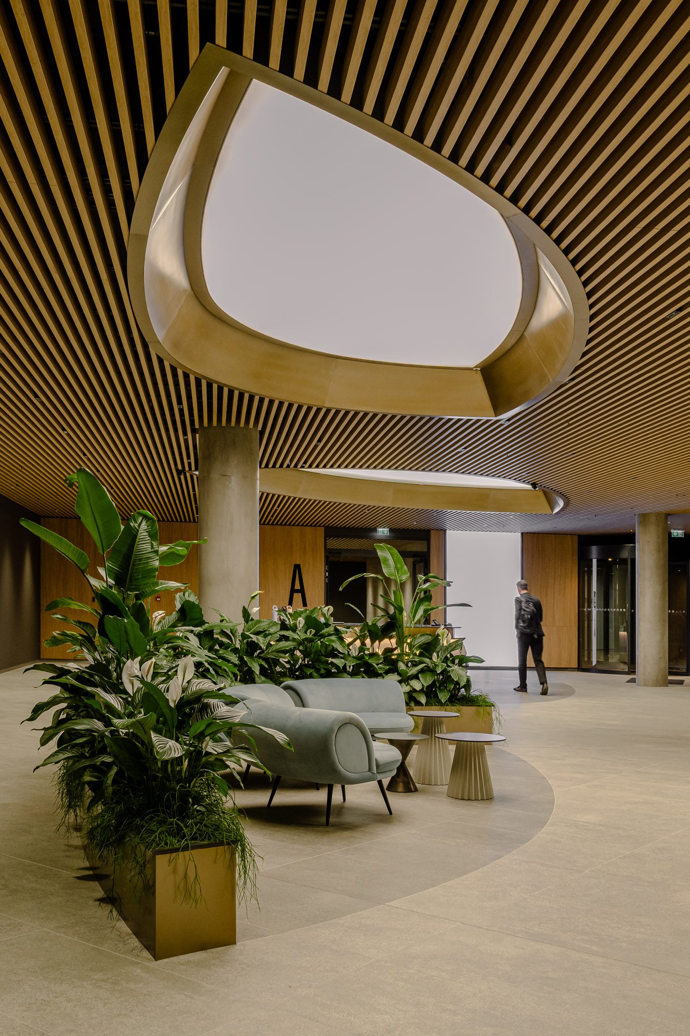 Lobby with timber-slatted ceiling, oval light well and planting, Business Stadium Central