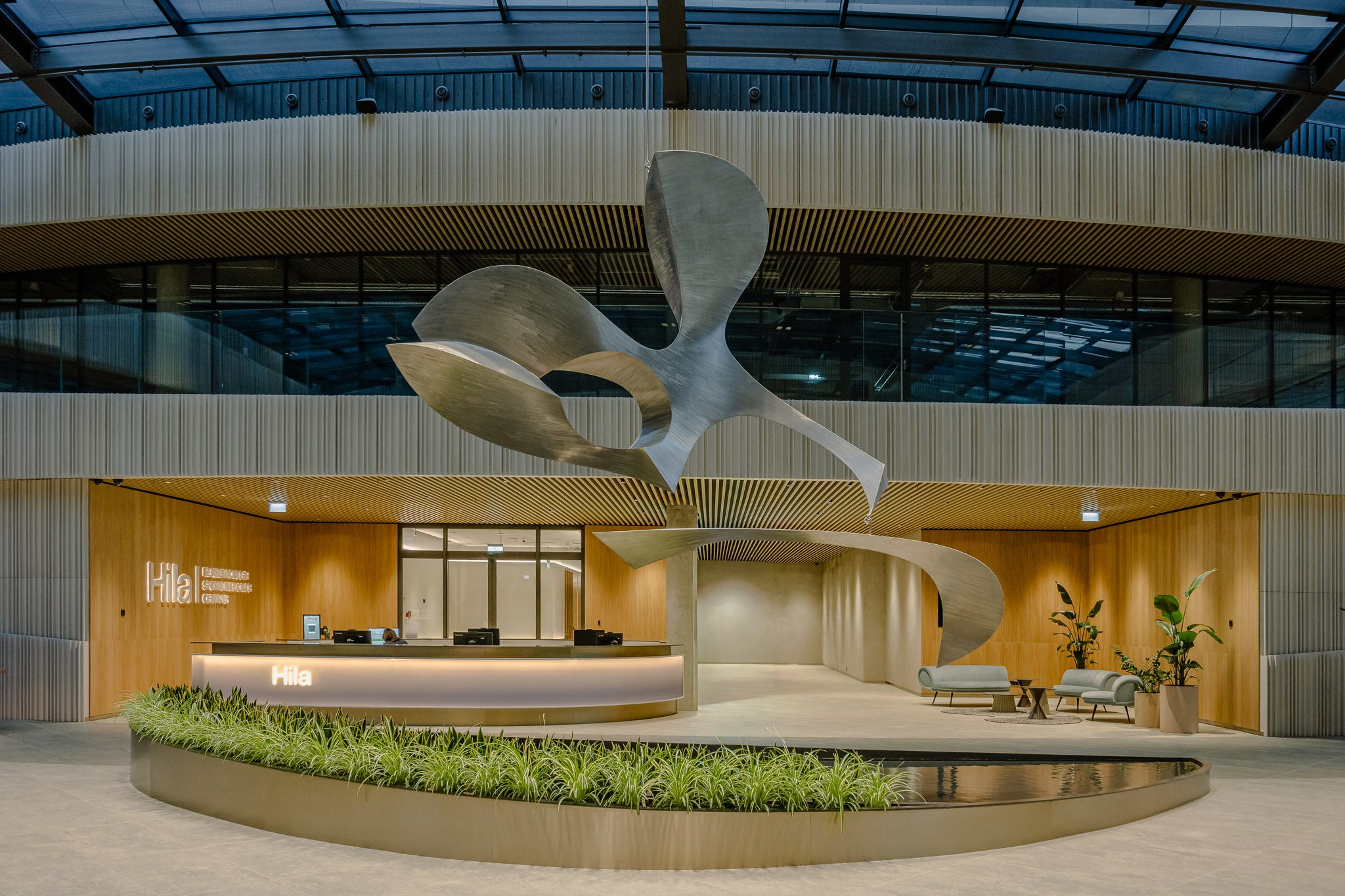 Reception beneath the kinetic sculpture in the glazed atrium of Business Stadium Central