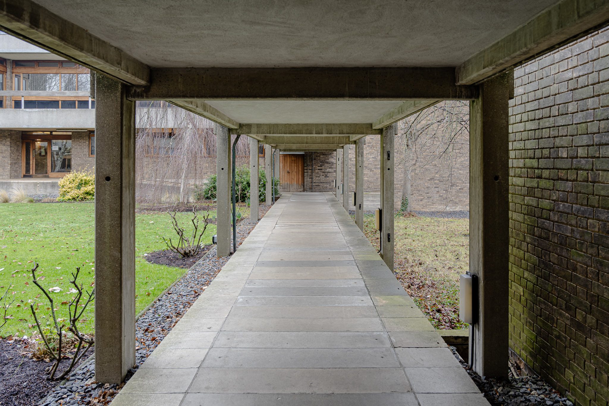 Covered walkway with timber posts across the courts, Churchill College