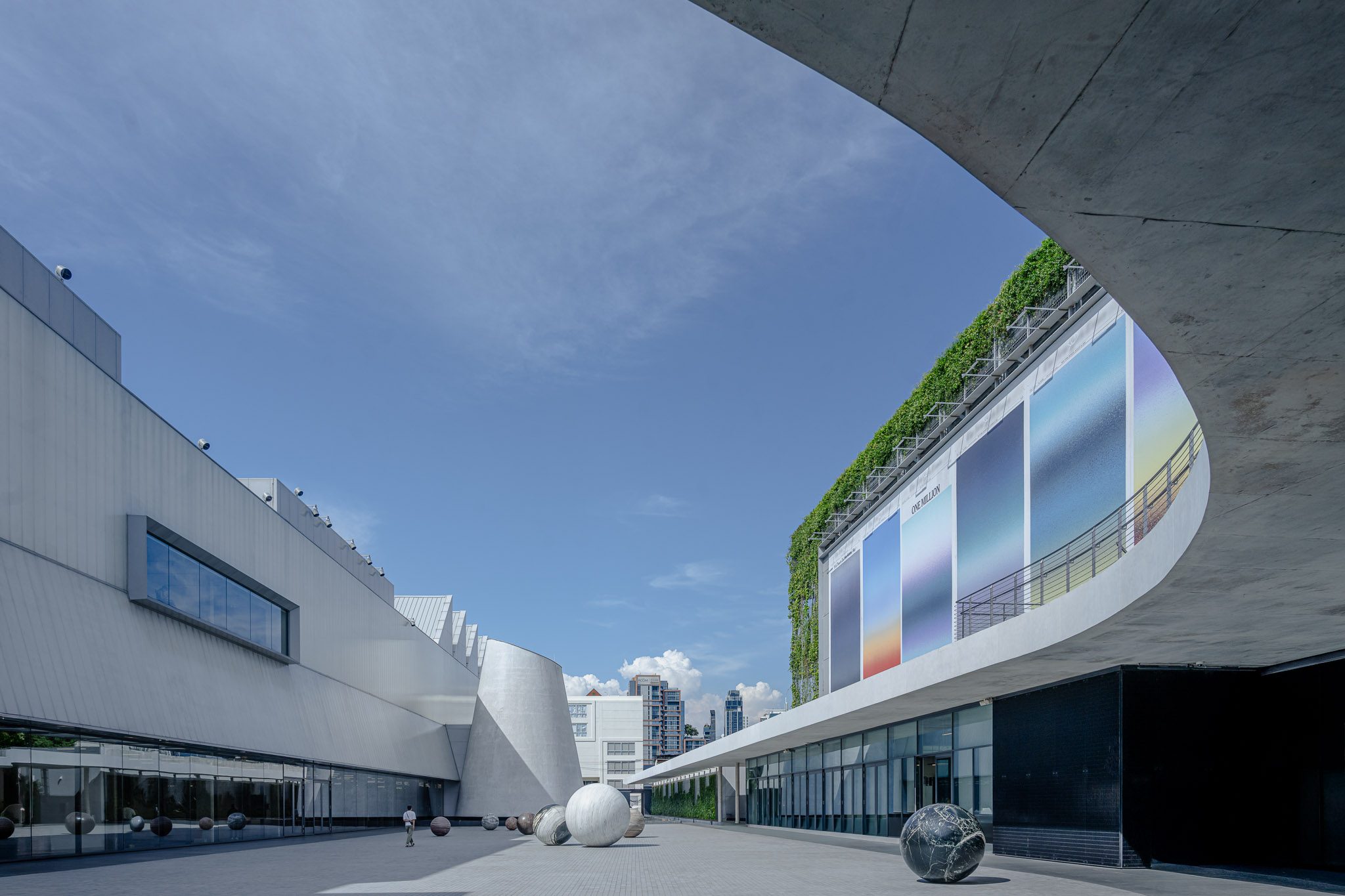 Curved concrete canopy framing the planted façade, Dib Bangkok