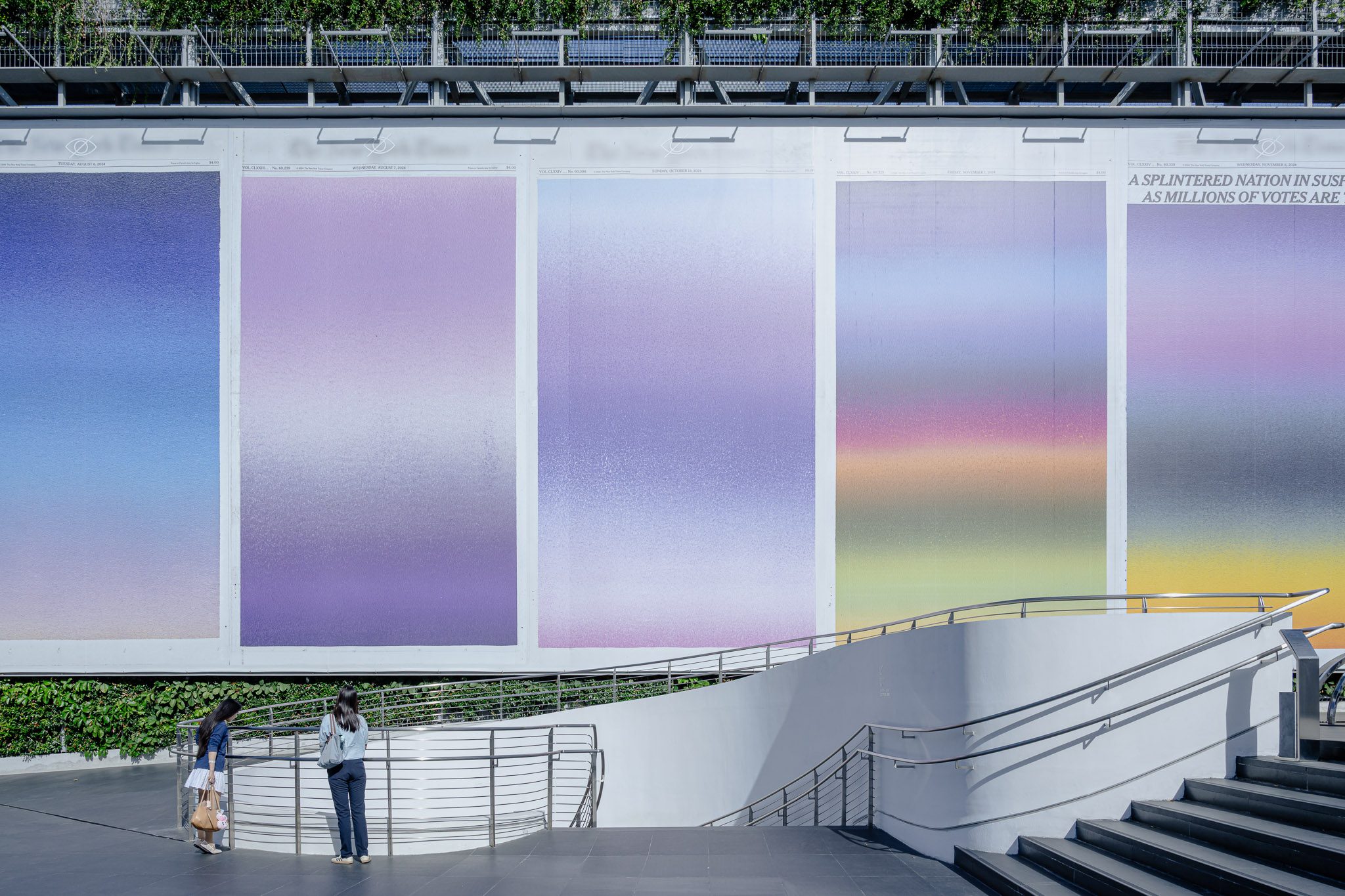 Visitors on the stair beneath the façade artwork, Dib Bangkok