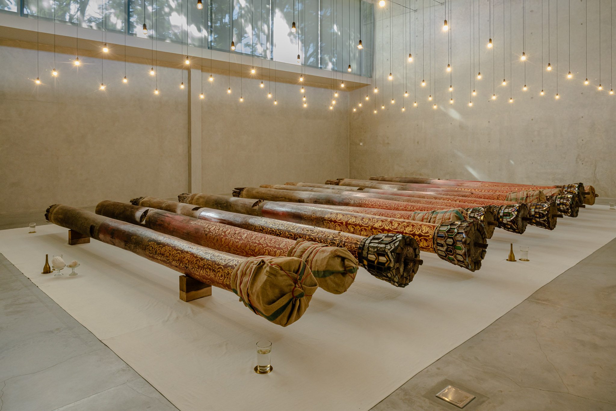 Gallery with carved timber sculptures and suspended lights, Dib Bangkok