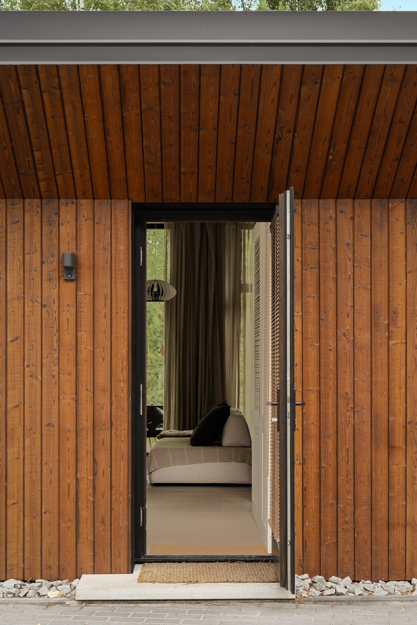 Open entrance door in vertical timber cladding, Forest Edge House