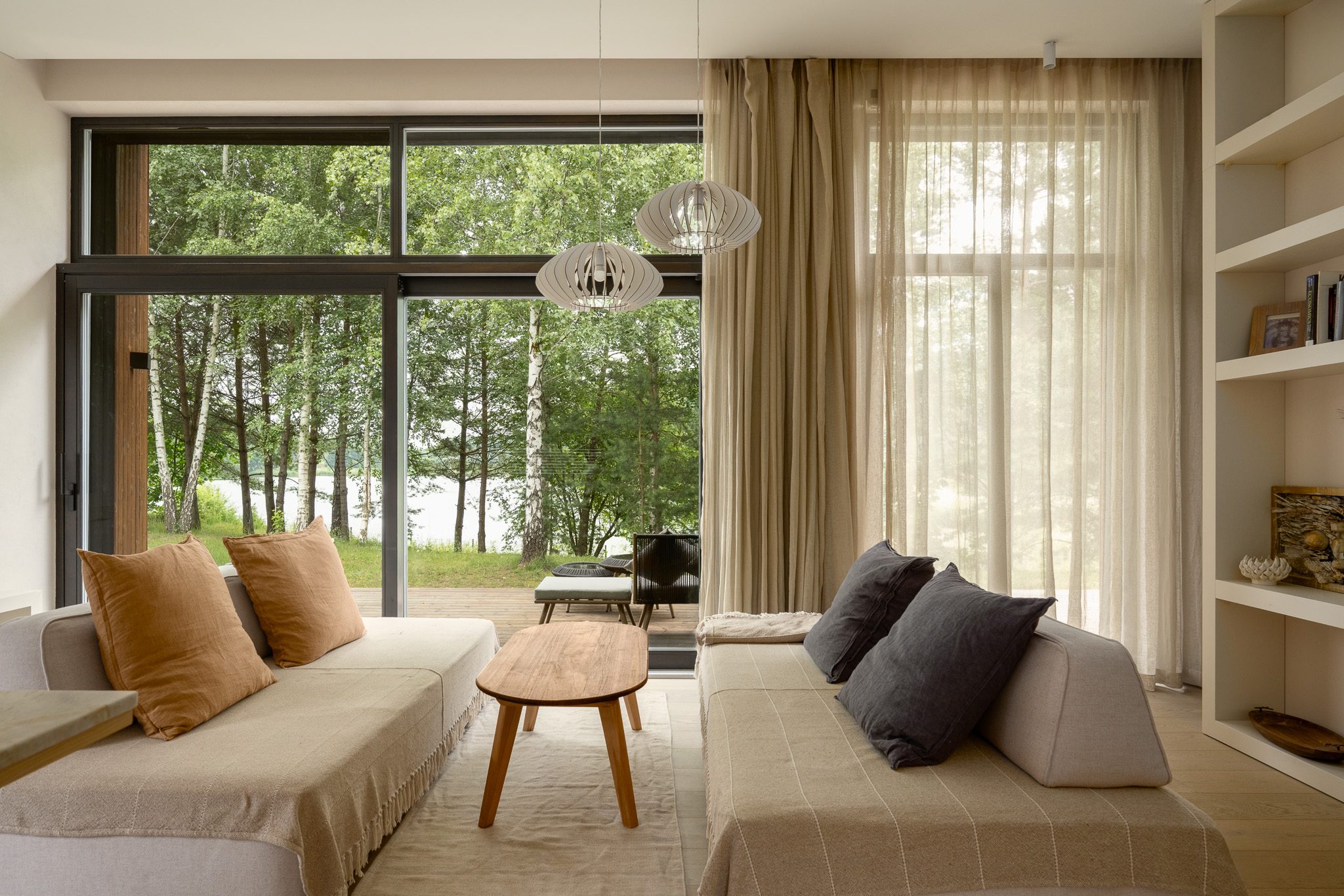 Living room with linen sofas and full-height windows onto the forest, Forest Edge House