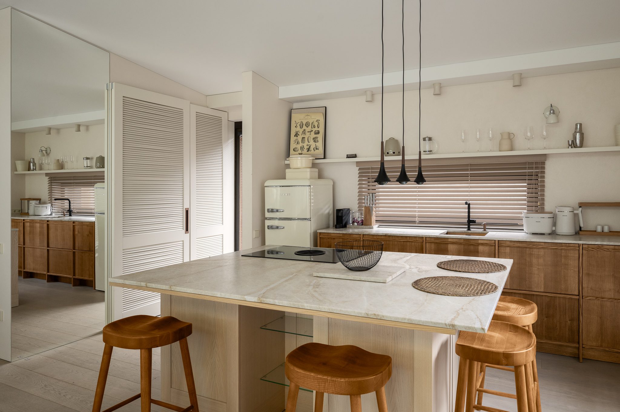 Kitchen with a marble island and wooden stools, Forest Edge House