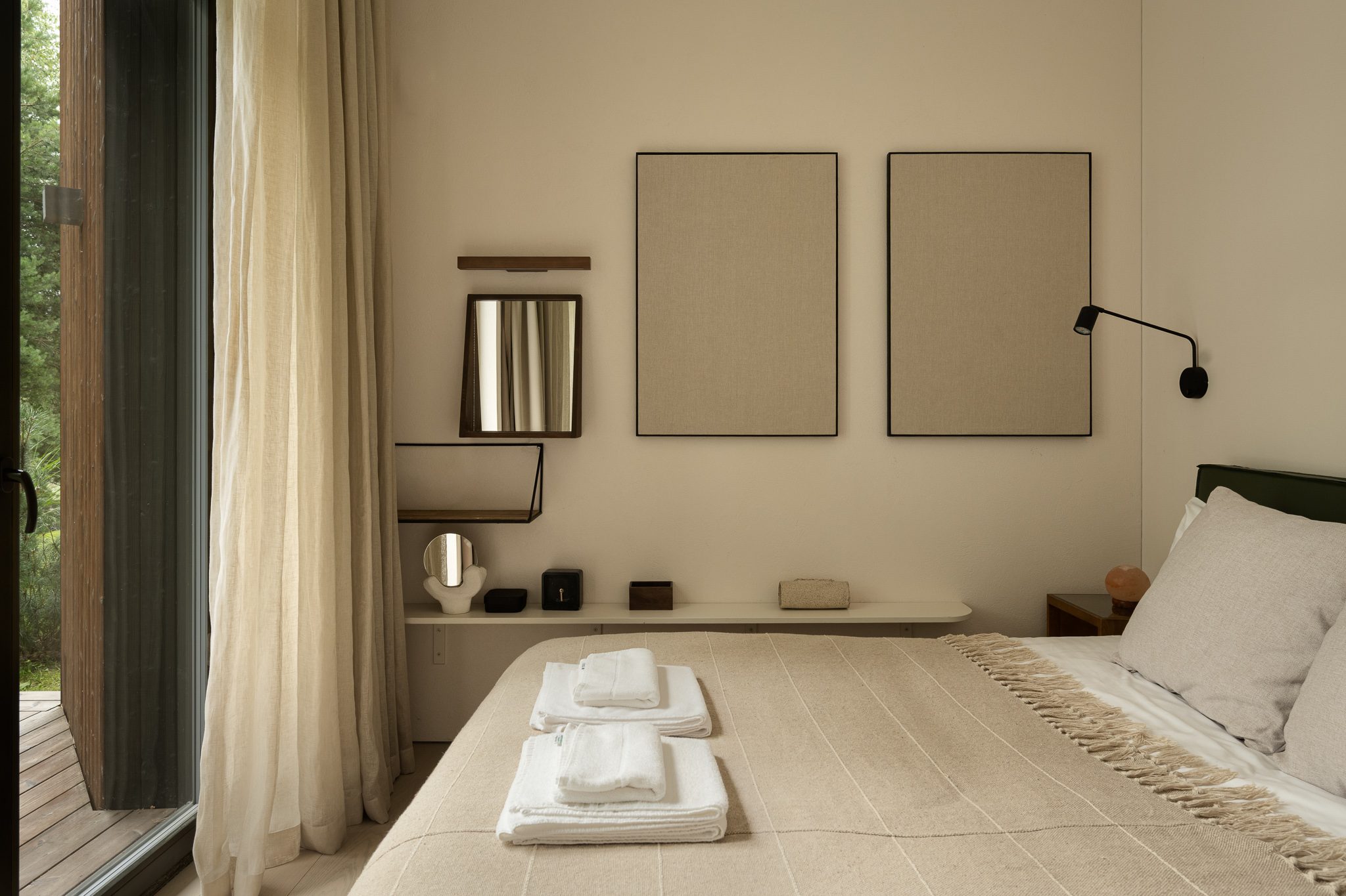 Bedroom with linen curtains and a window onto the trees
