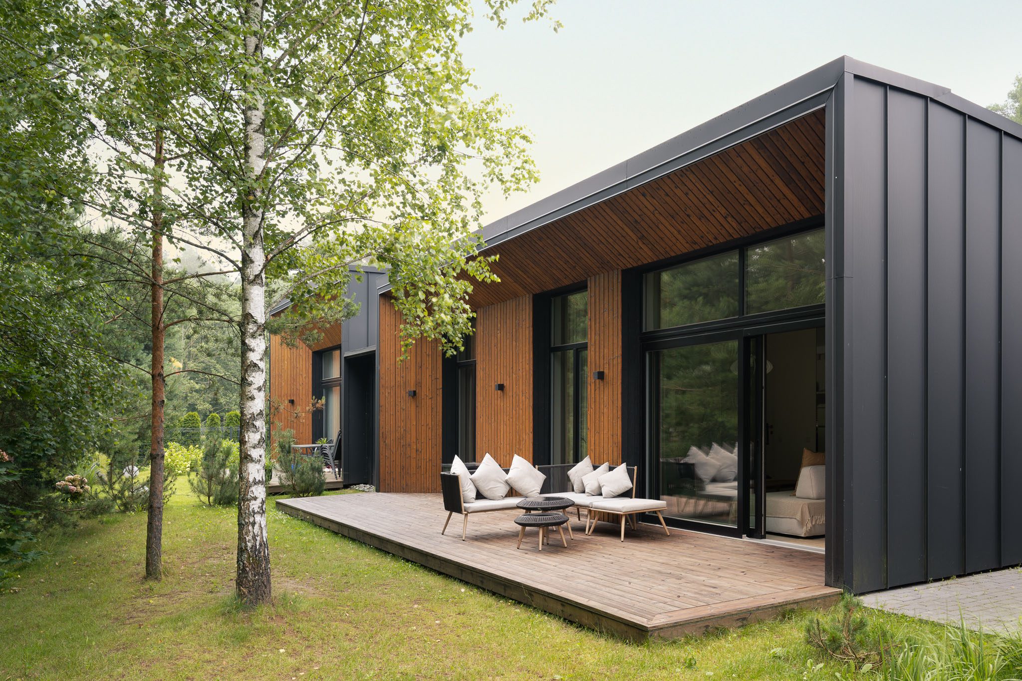 Deck and outdoor seating beside the house among birch trees