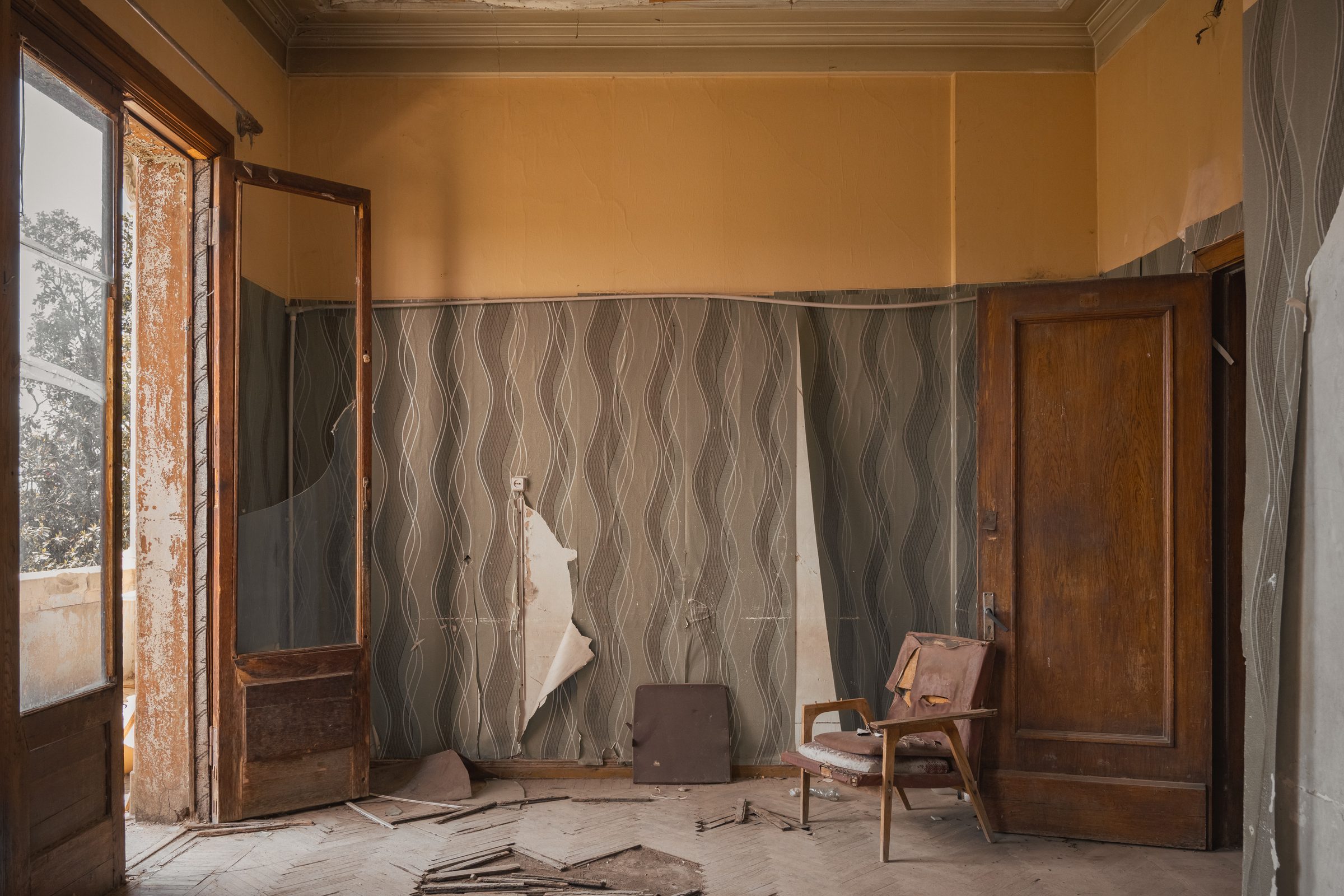 Patient room with peeling wallpaper and an armchair, Sanatorium Metallurgist