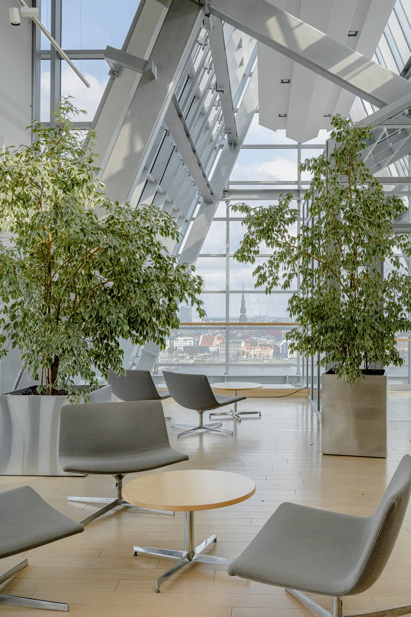 Lounge chairs and trees beneath the glazed roof, National Library of Latvia