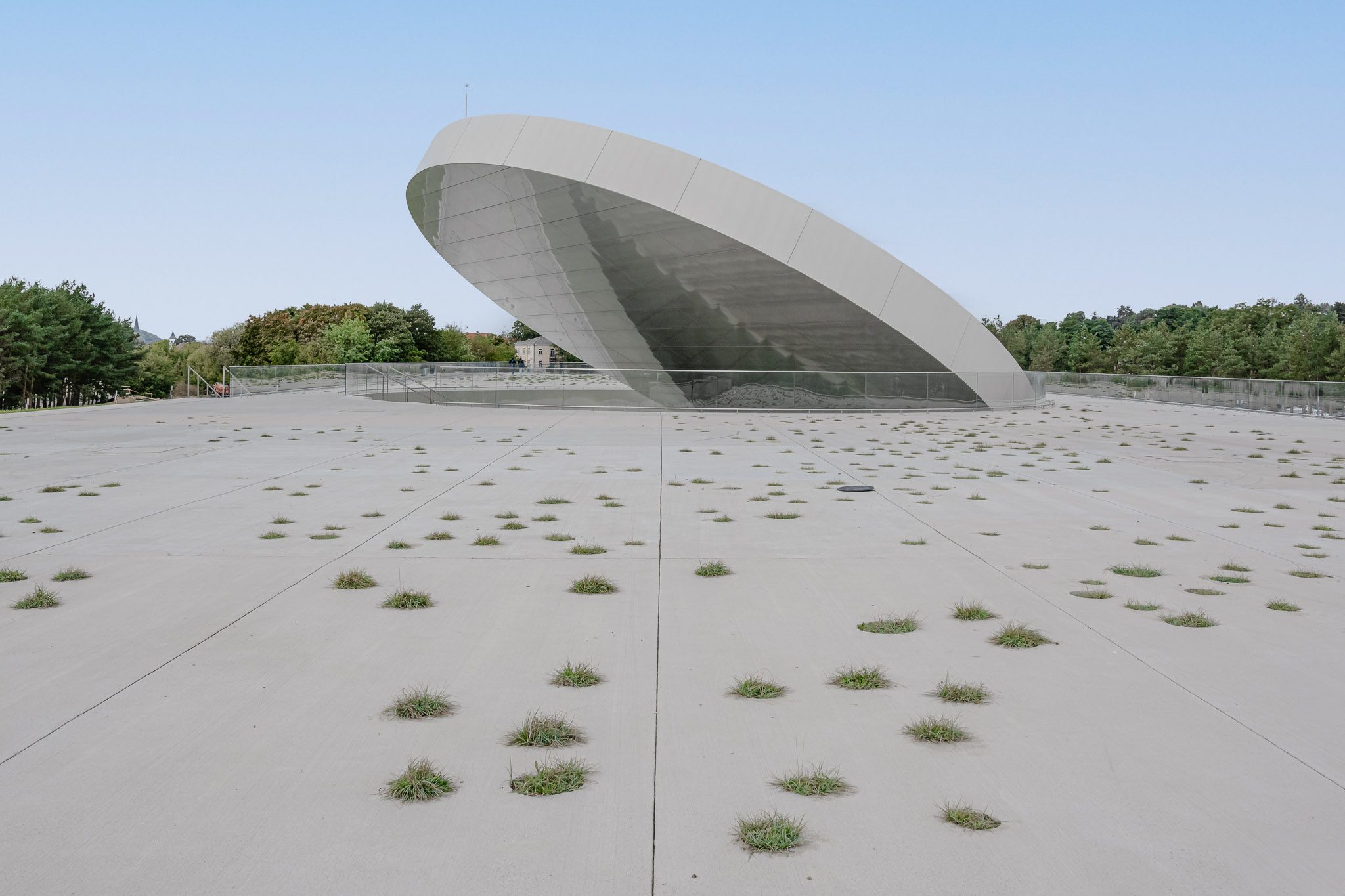 Tilted reflective disc rising from the planted roof, Mokslo Sala