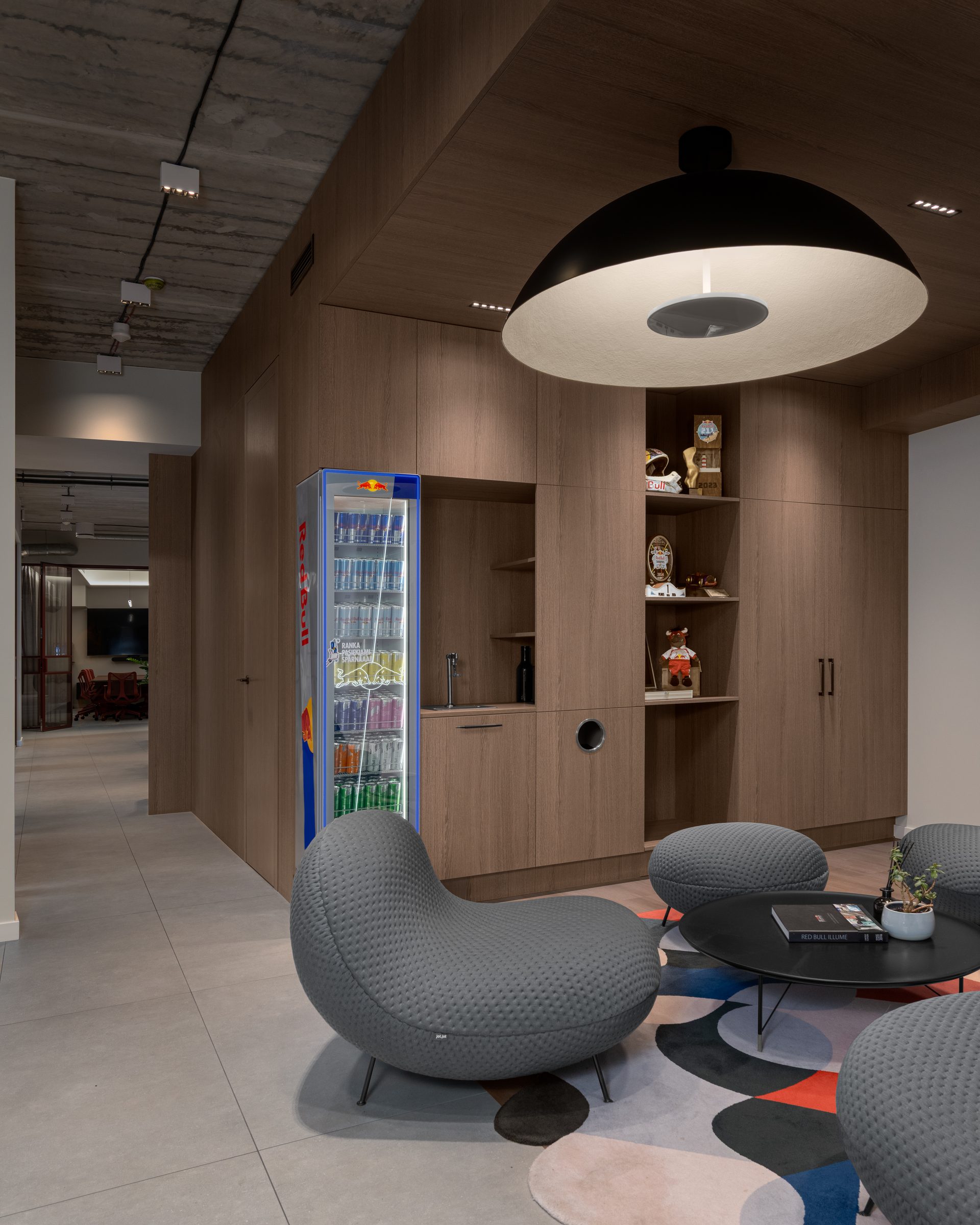 Lounge with pendant lamp, soft seating and branded cooler, Red Bull office, Vilnius