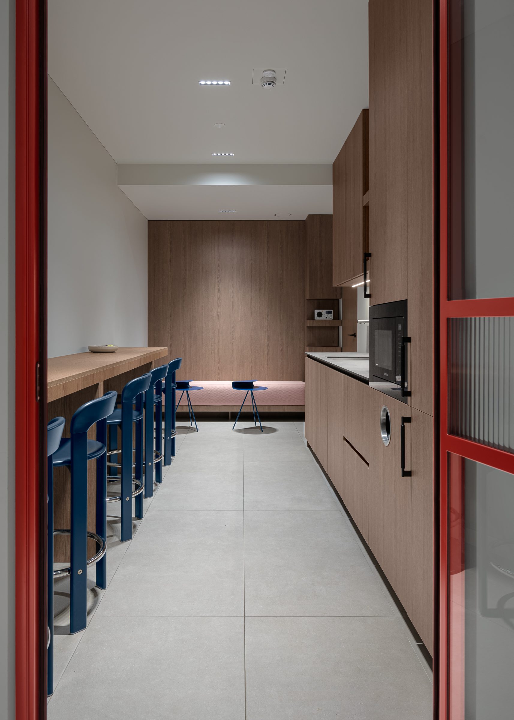 Kitchen with walnut joinery and blue bar stools, Red Bull office
