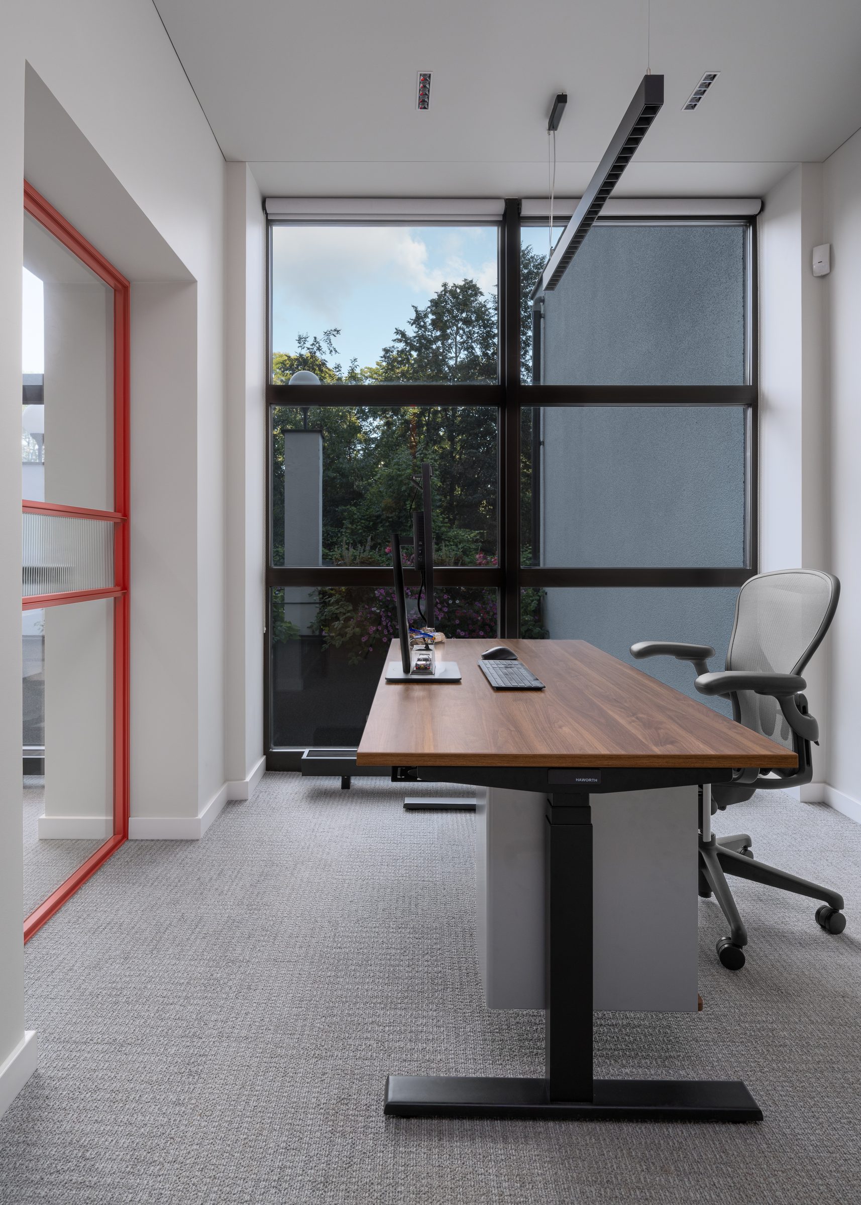 Private office with a walnut desk and a window onto the trees, Red Bull office