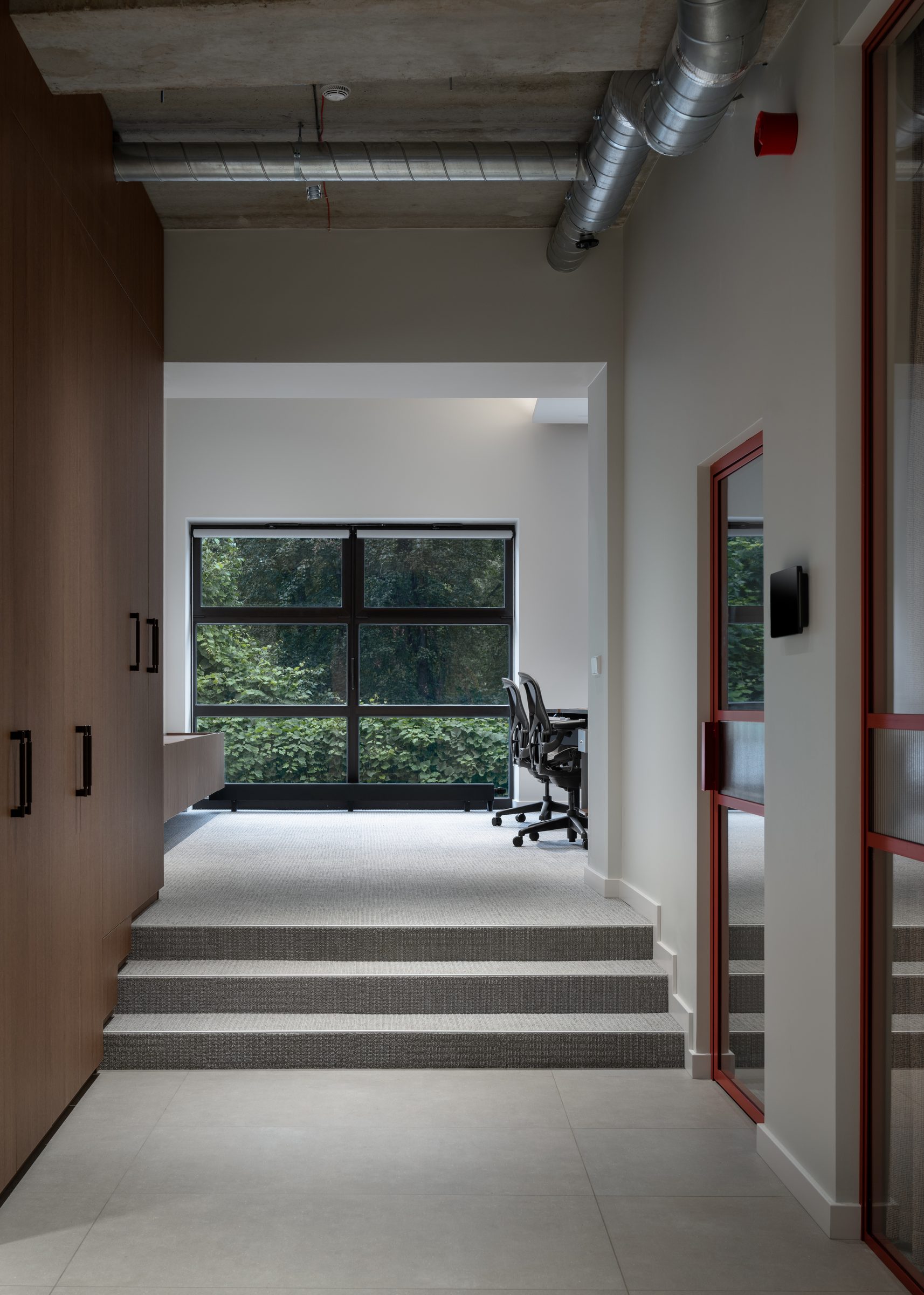 Corridor with steps leading to a workspace by the window, Red Bull office