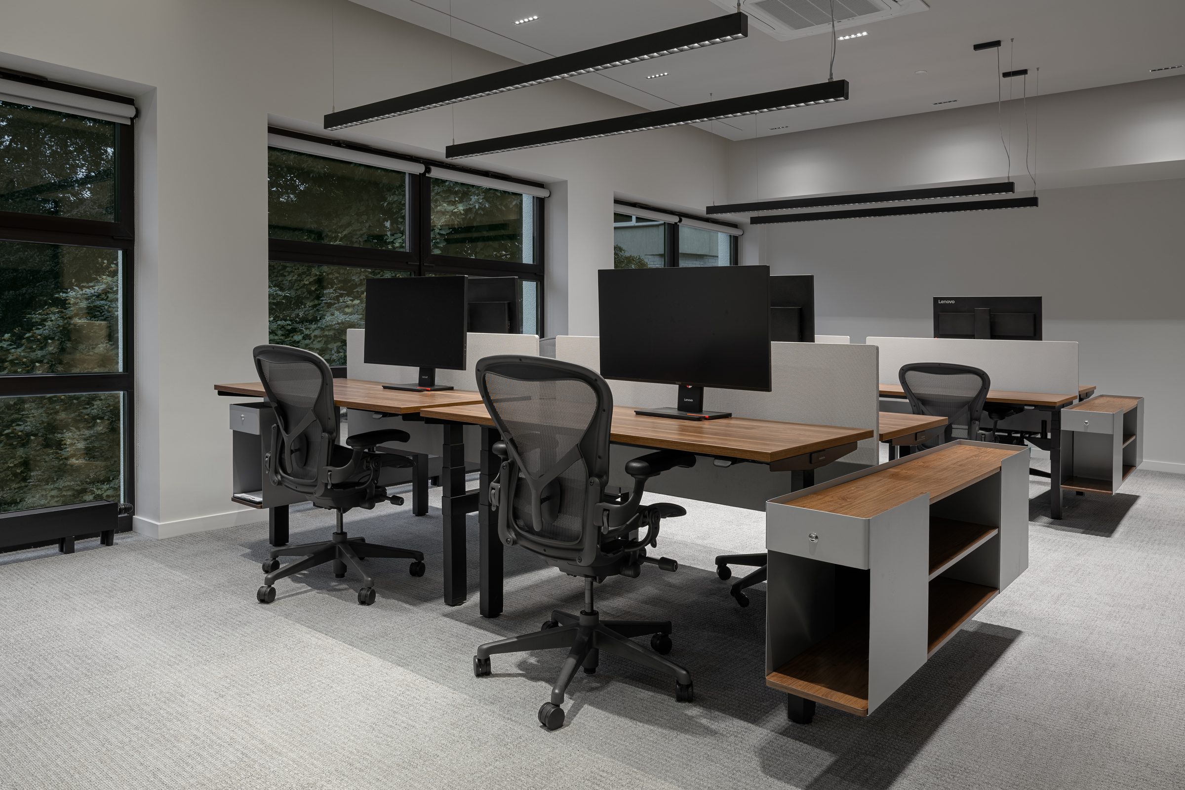 Open workspace with sit-stand desks and full-height windows, Red Bull office