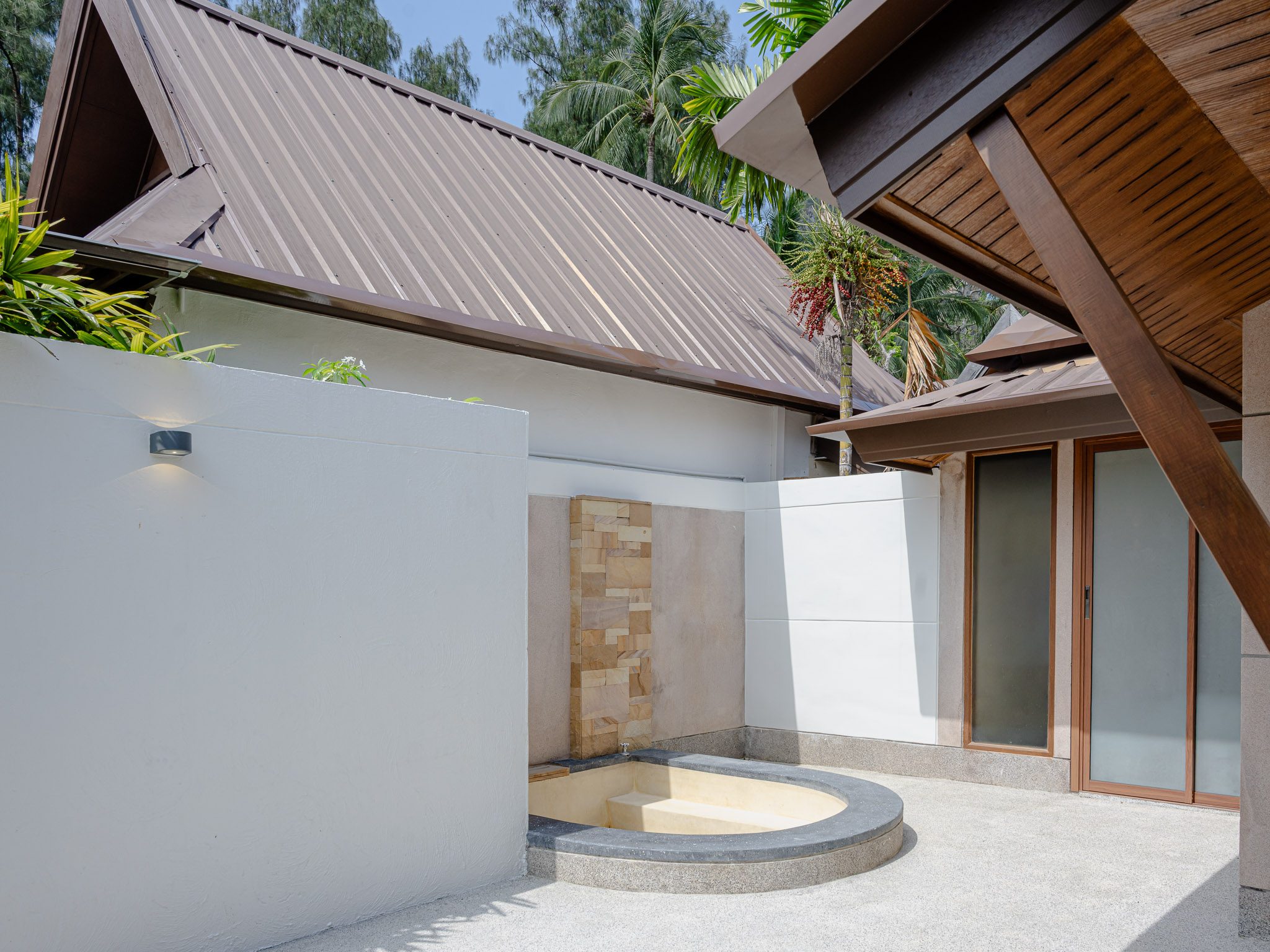 Plunge pool and stone water wall in a villa courtyard, Thai Cottage