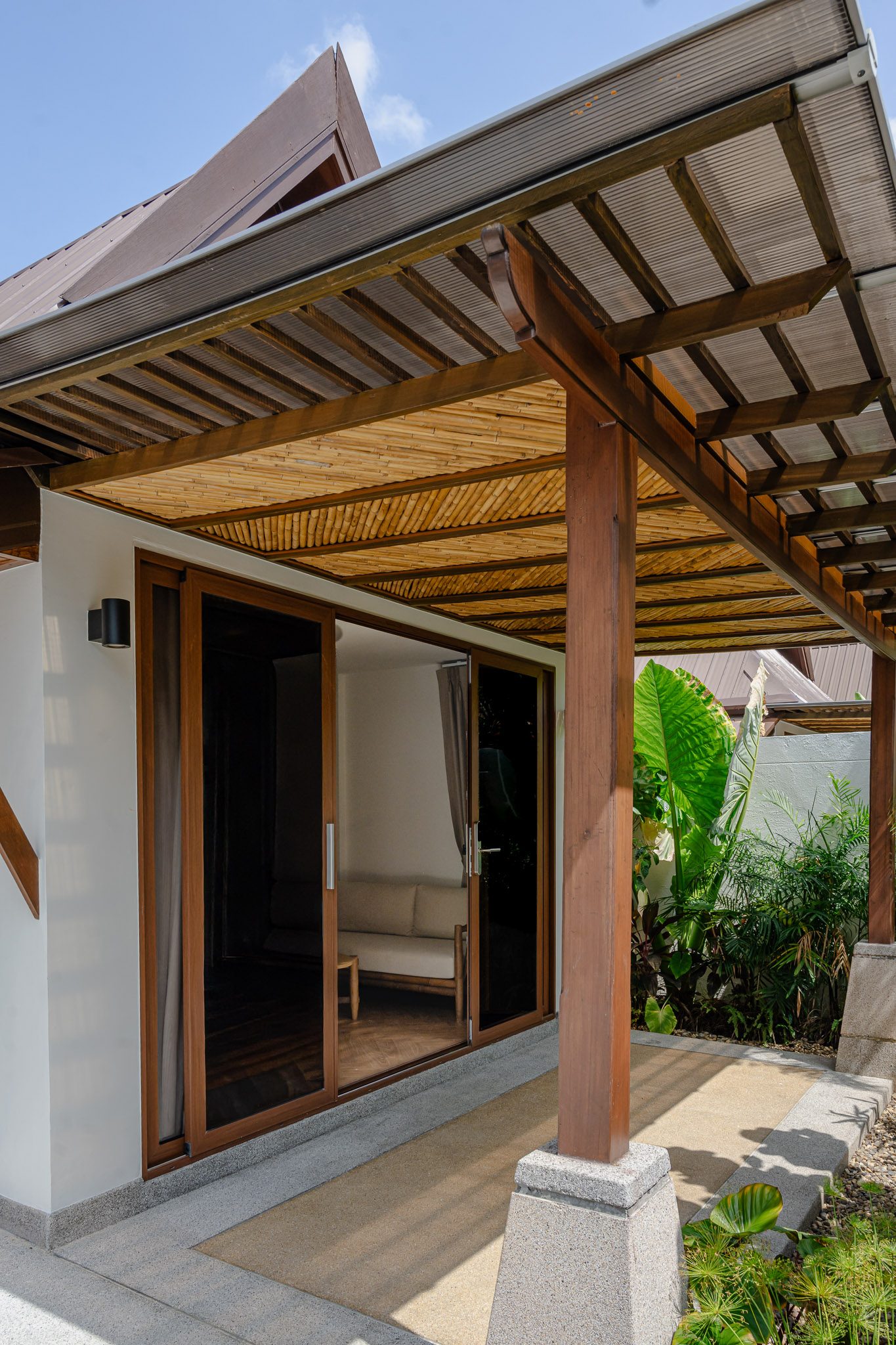 Covered terrace with bamboo ceiling outside a villa, Thai Cottage