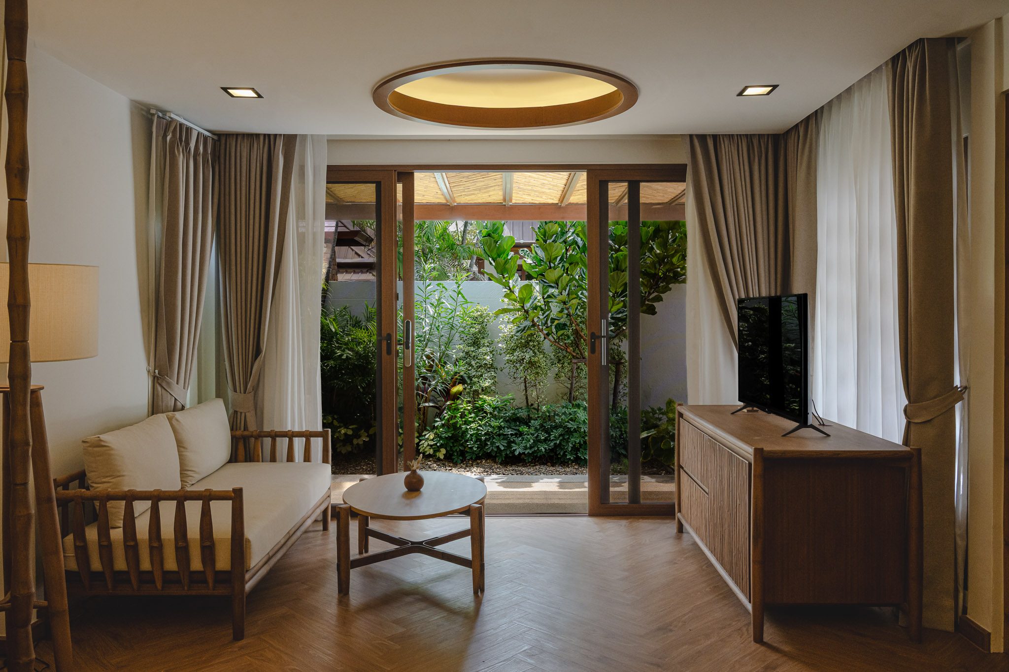 Living room opening onto a tropical garden, Thai Cottage