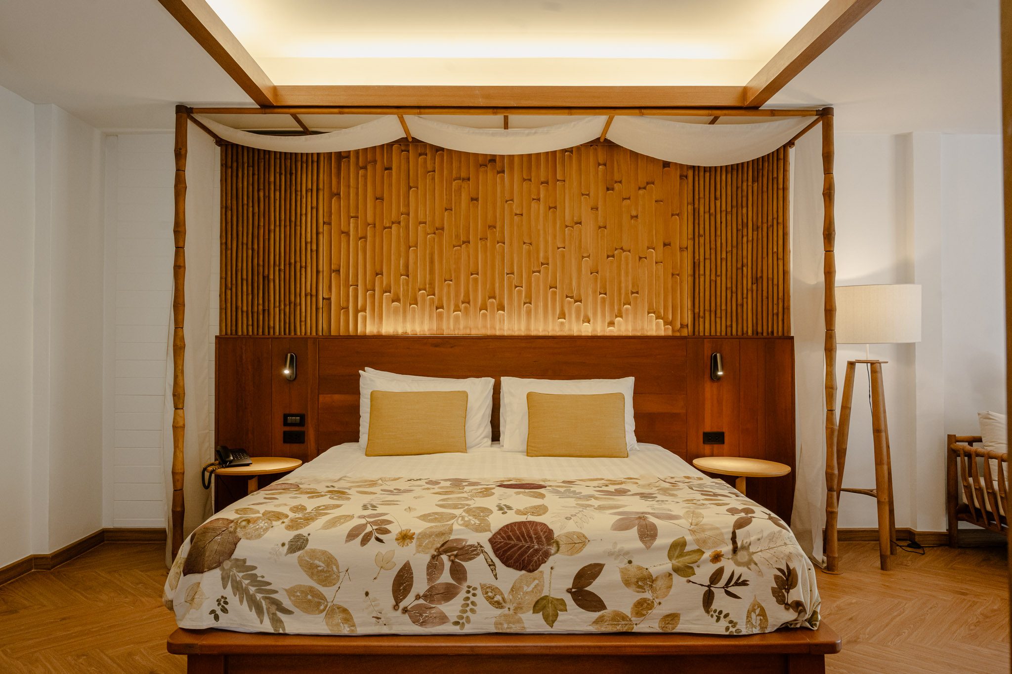 Bamboo-panelled headboard and leaf-print bedspread, Thai Cottage