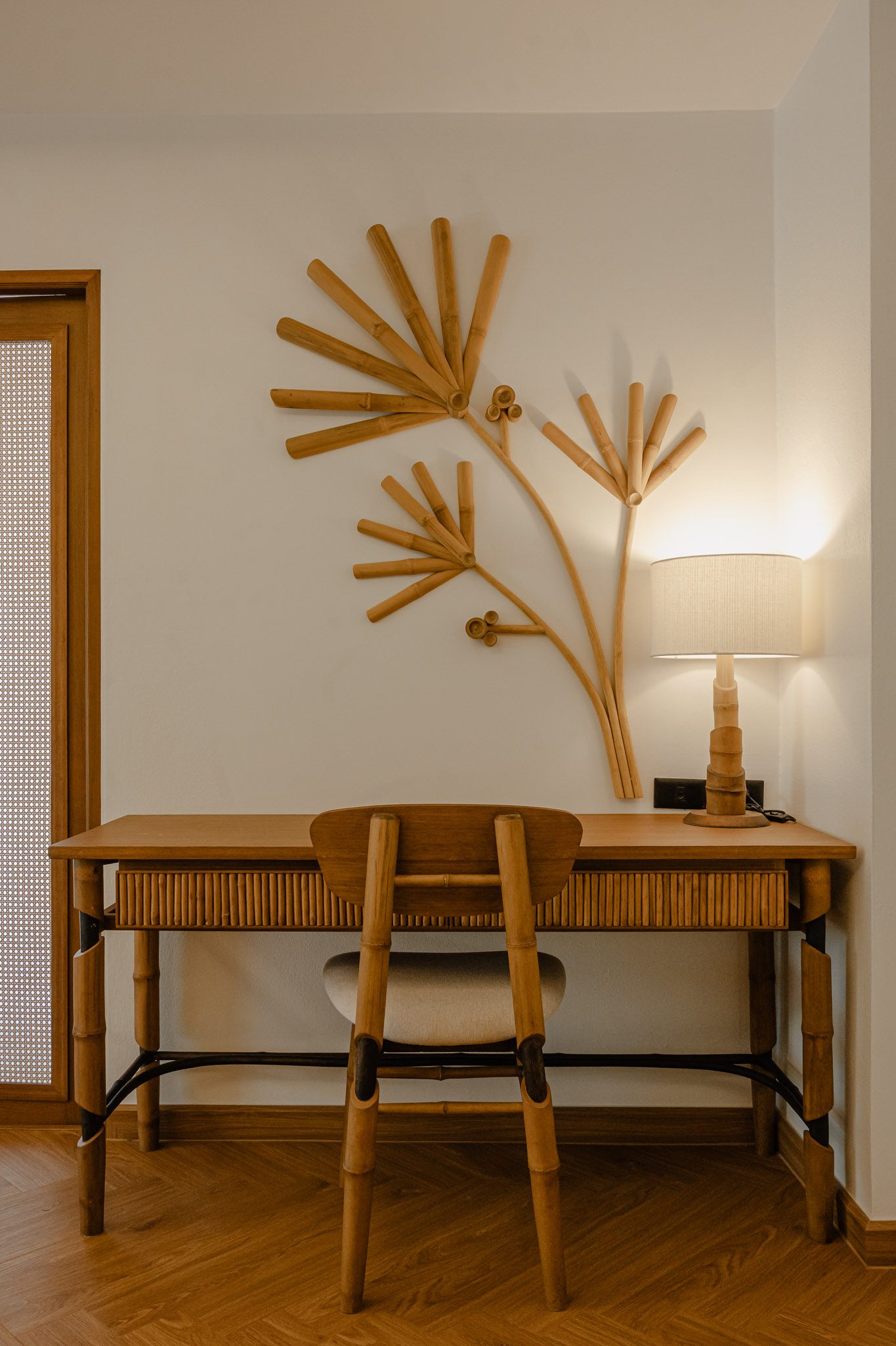 Bamboo desk beneath a sculpted bamboo wall piece, Thai Cottage